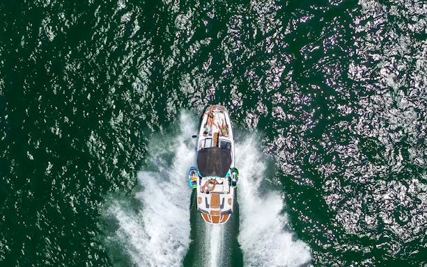Speed boat with people cruising on open water.