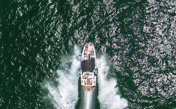 Speed boat with people cruising on open water.