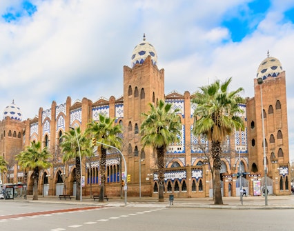 Plaza de Toros Monumental de Barcelona with Moorish architecture and palm trees.