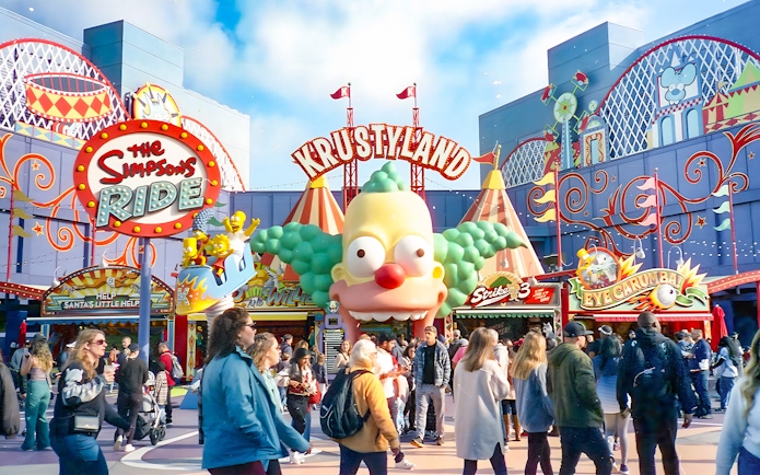 Krustyland entrance at Universal Studios Orlando with The Simpsons Ride sign and visitors.