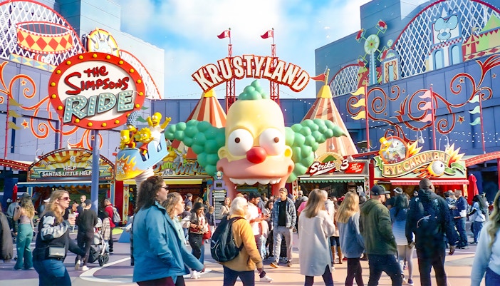Krustyland entrance at Universal Studios Orlando with The Simpsons Ride sign and visitors.
