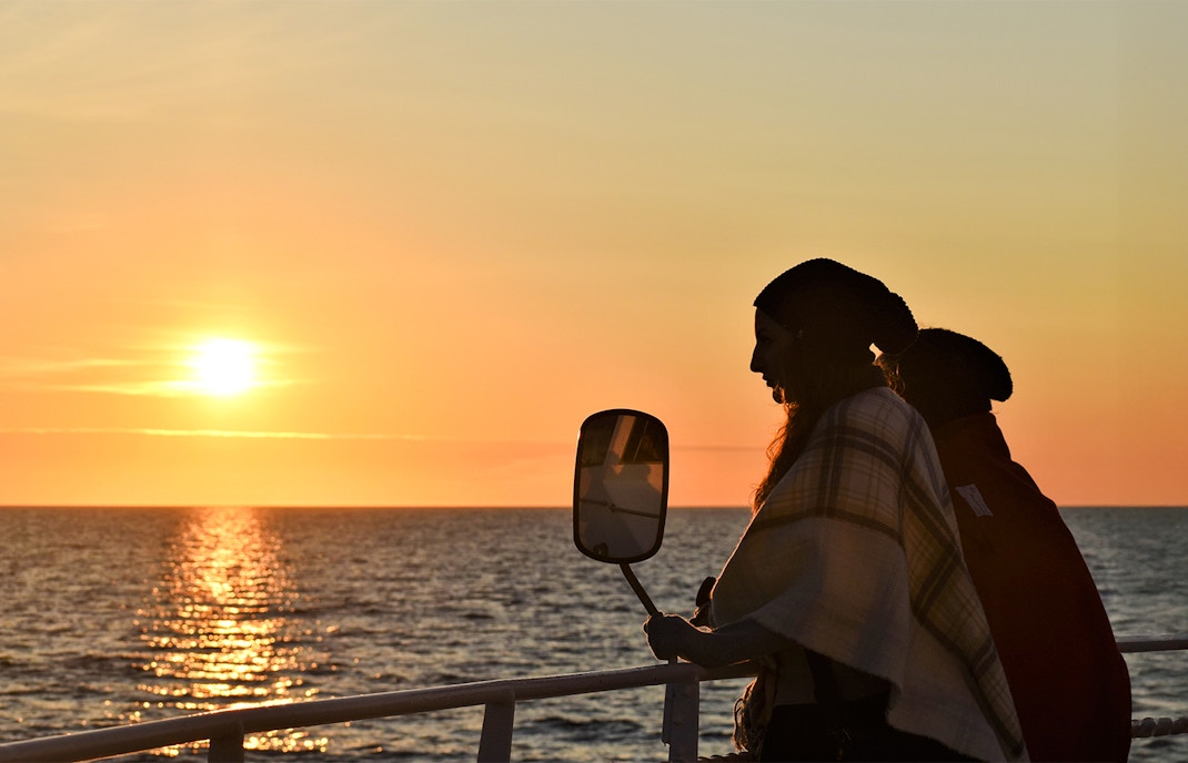 Visitor on deck during Reykjavik Classic Whales tour at sunset.