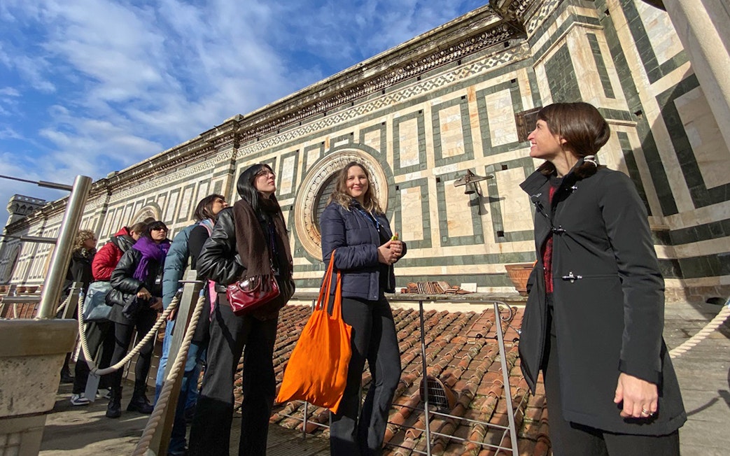 Visitors with a guide on the terrace of Florence Cathedral, Italy.