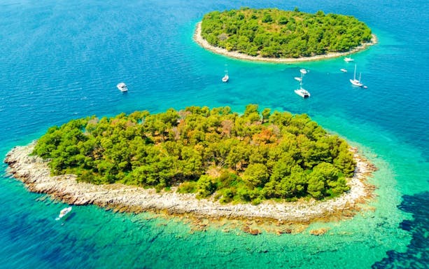 Aerial view of islands in the Blue Lagoon with boats in turquoise water.
