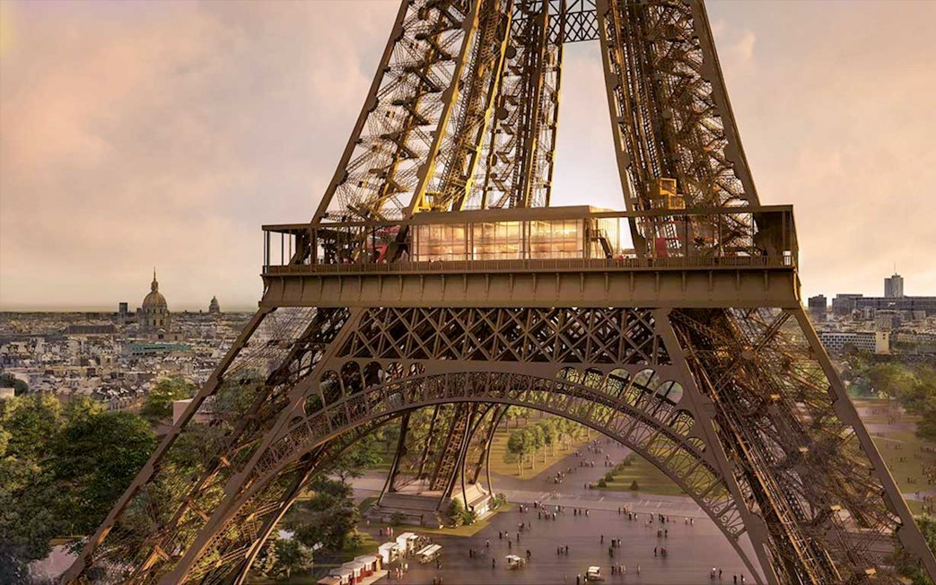 Eiffel Tower's Madame Brasserie exterior with Paris skyline in the background.