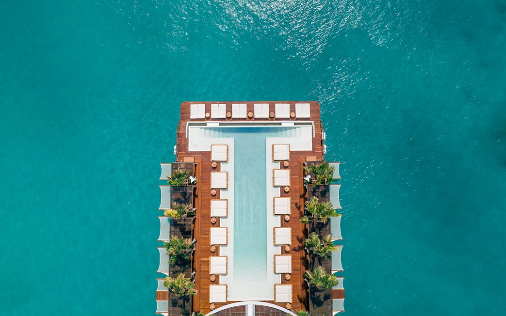 Floating pool deck at Yona Beach Club, Phuket, surrounded by turquoise water.