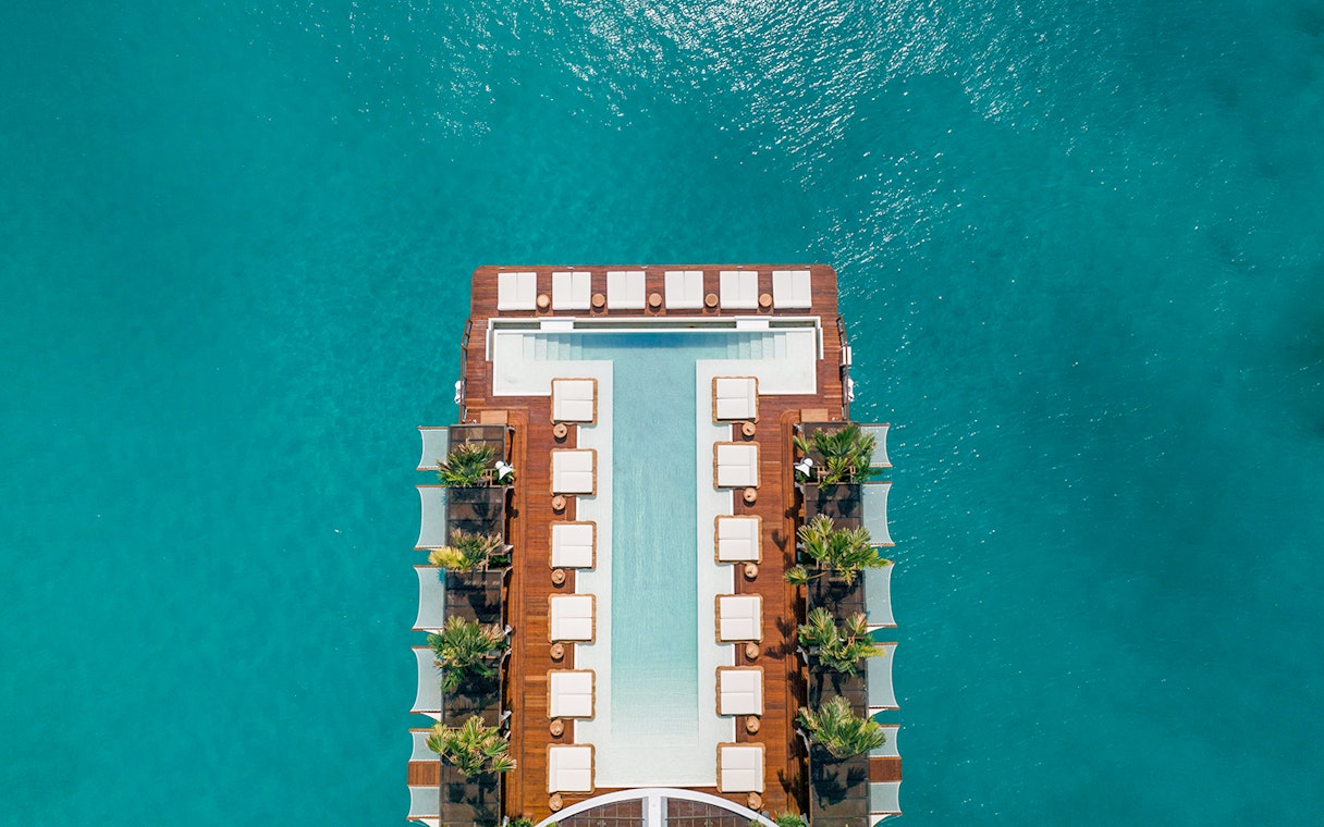 Floating pool deck at Yona Beach Club, Phuket, surrounded by turquoise water.