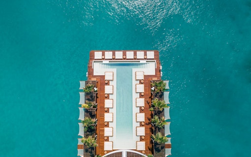 Floating pool deck at Yona Beach Club, Phuket, surrounded by turquoise water.