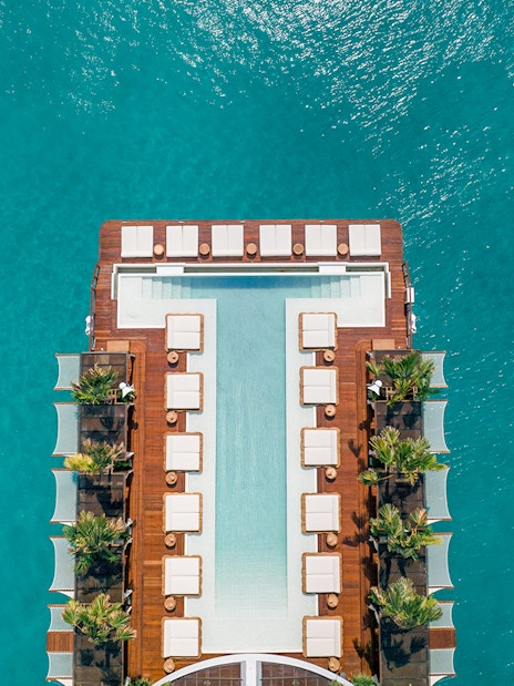 Floating pool deck at Yona Beach Club, Phuket, surrounded by turquoise water.