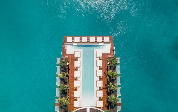 Floating pool deck at Yona Beach Club, Phuket, surrounded by turquoise water.
