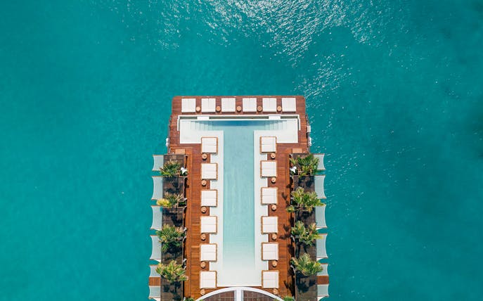Floating pool deck at Yona Beach Club, Phuket, surrounded by turquoise water.