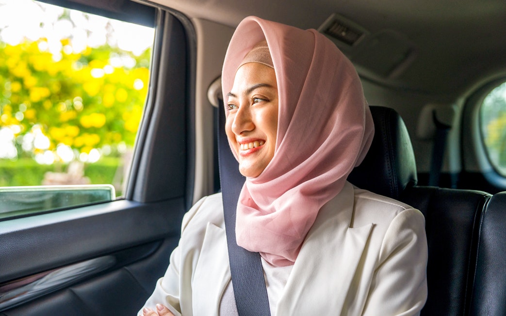 Person smiling in a car during transfer to Ubud Jambangan Bali Cooking Class.