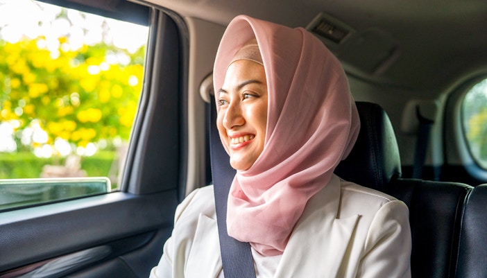 Person smiling in a car during transfer to Ubud Jambangan Bali Cooking Class.