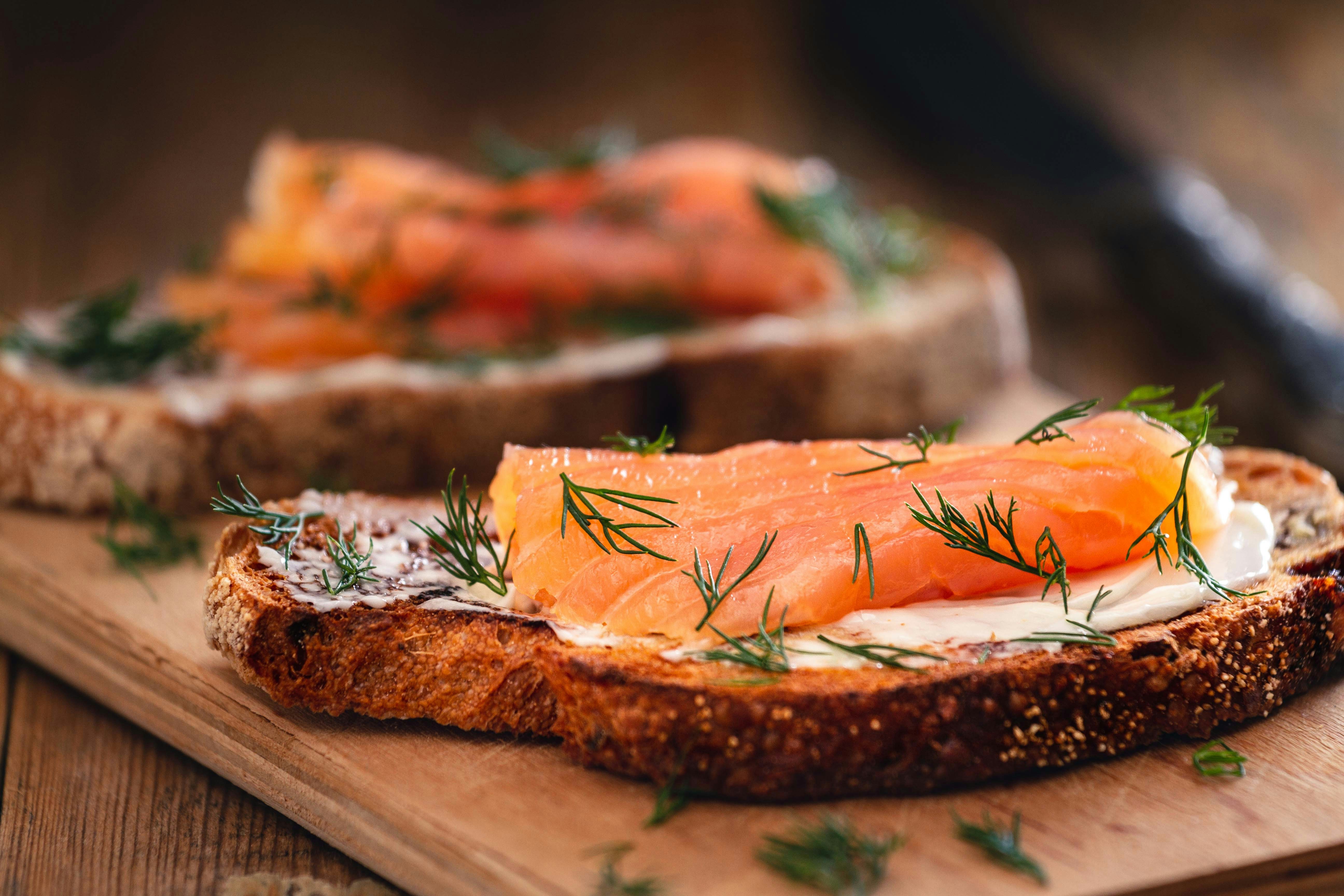 Smoked salmon on rye bread with cream cheese and dill.