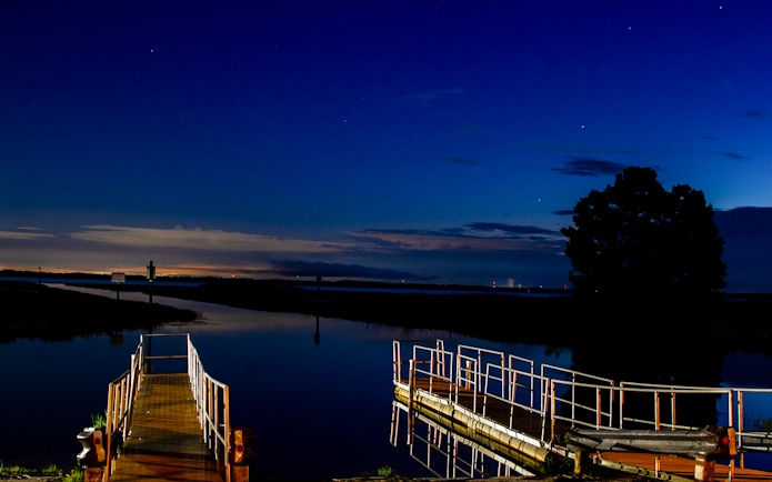 Night view of a dock and waterway during Boggy Creek 1 Hour Night Airboat Tour.