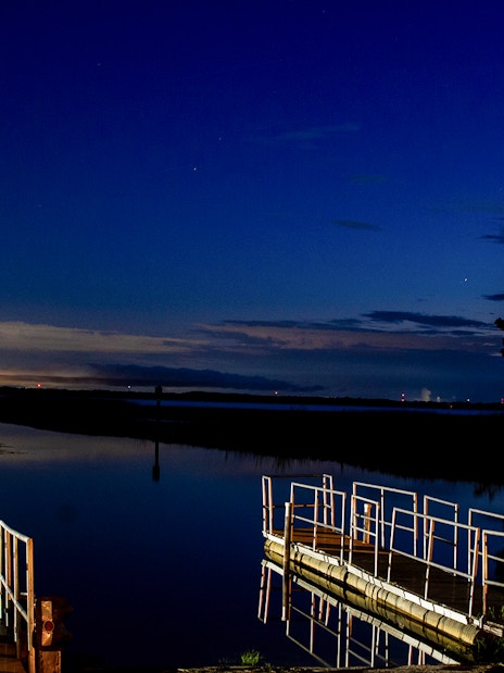 Night view of a dock and waterway during Boggy Creek 1 Hour Night Airboat Tour.