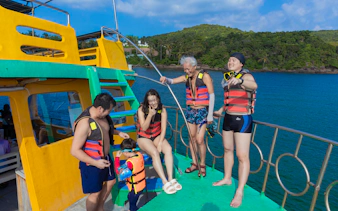 Tourists in life vests on a boat at Hon Thom Cable Car, preparing for snorkeling tour.
