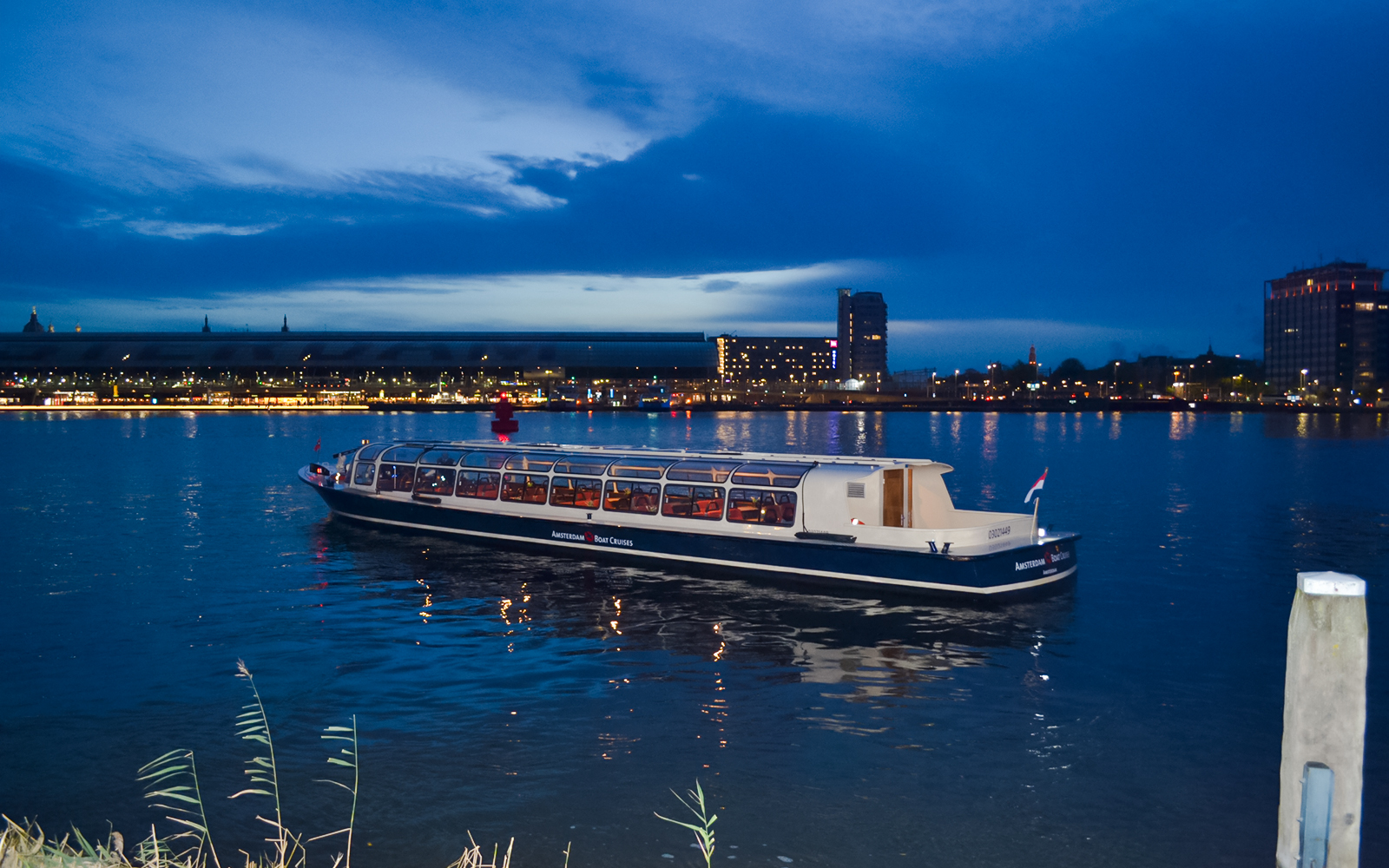 Amsterdam canal cruise boat during the Light Festival at dusk.