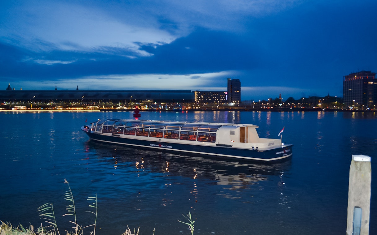 Amsterdam canal cruise boat during the Light Festival at dusk.