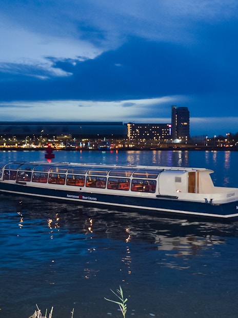 Amsterdam canal cruise boat during the Light Festival at dusk.