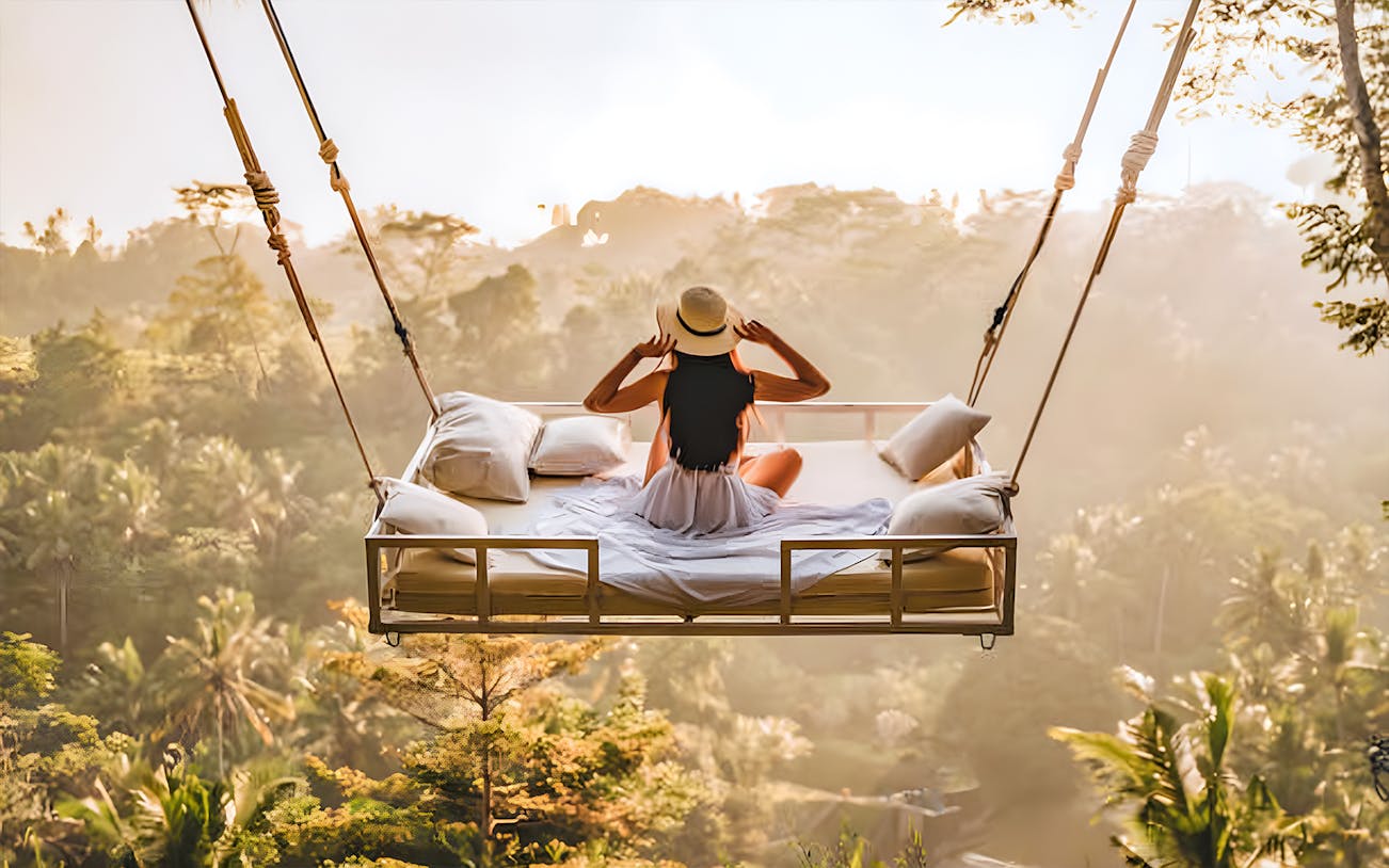 Person on swing overlooking Bali jungle during customized tour.
