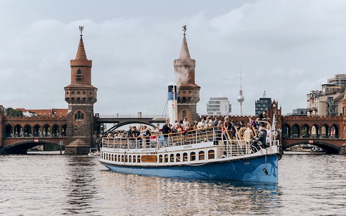 Berlin bridge cruise boat on Spree River near Oberbaum Bridge.