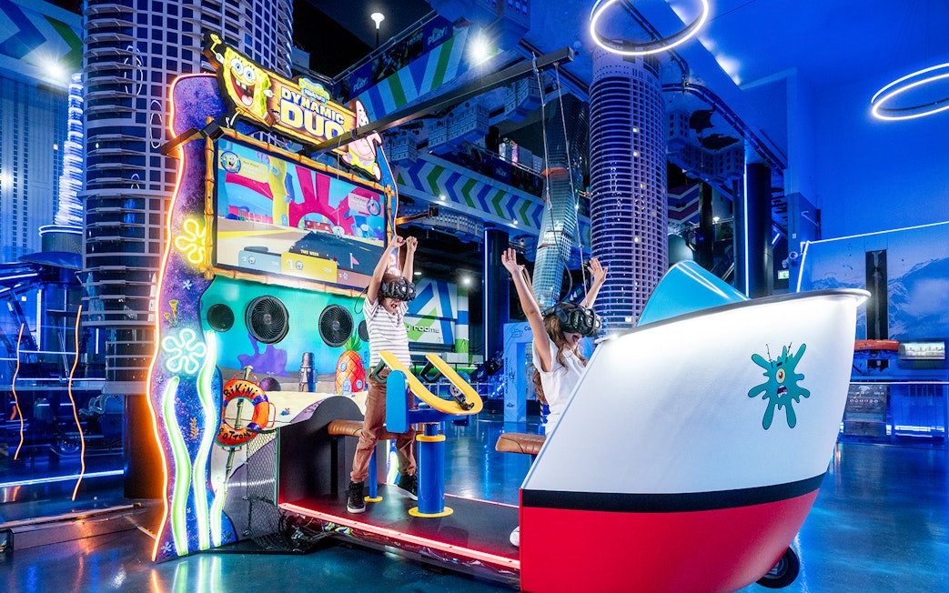 Children enjoying virtual reality game at Play DXB, Dubai with VR headsets and interactive controls.