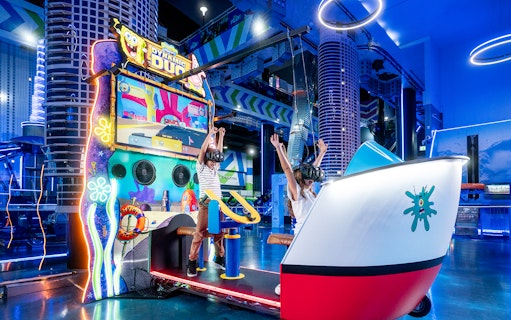 Children enjoying virtual reality game at Play DXB, Dubai with VR headsets and interactive controls.