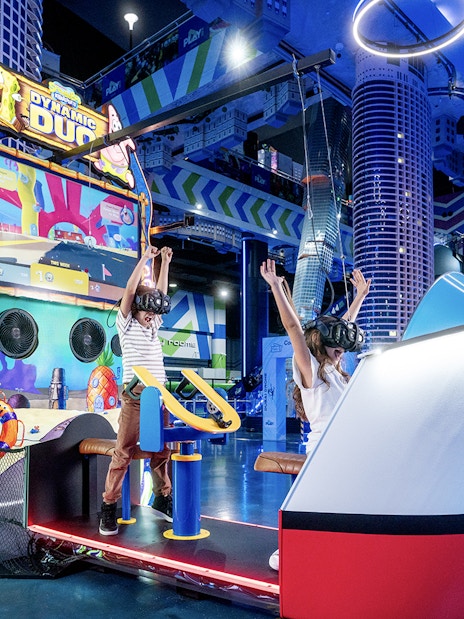 Children enjoying virtual reality game at Play DXB, Dubai with VR headsets and interactive controls.