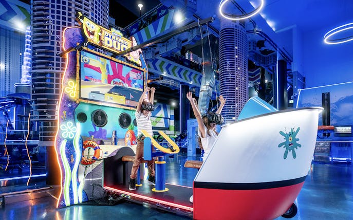 Children enjoying virtual reality game at Play DXB, Dubai with VR headsets and interactive controls.