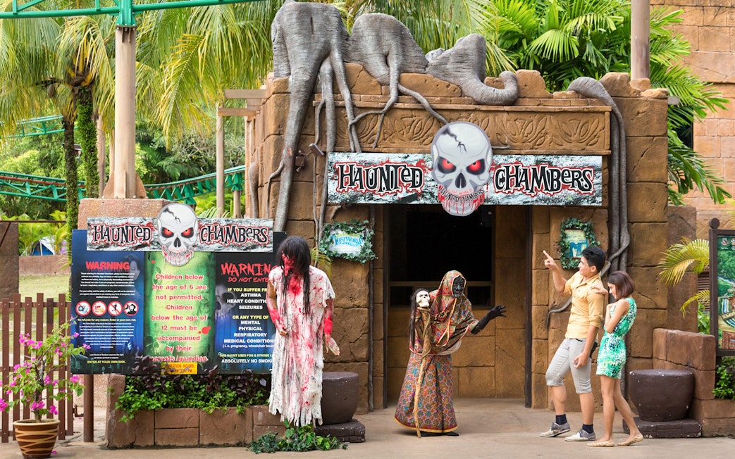 Haunted Chambers entrance at Sunway Lost World of Tambun with visitors and costumed figures.