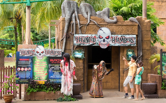 Haunted Chambers entrance at Sunway Lost World of Tambun with visitors and costumed figures.