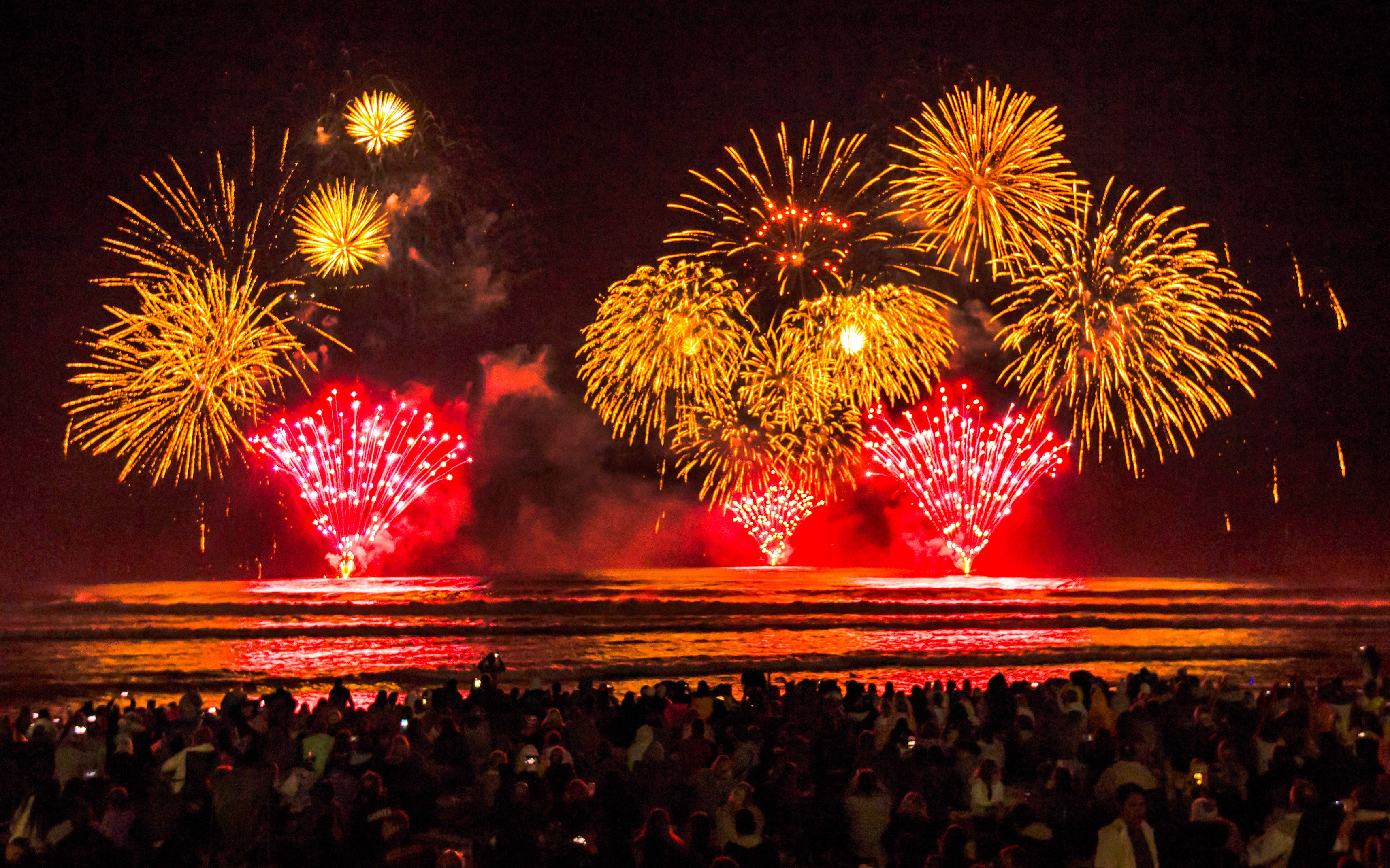 Fireworks display over Surfers Paradise Beach, Gold Coast, with a crowd watching.