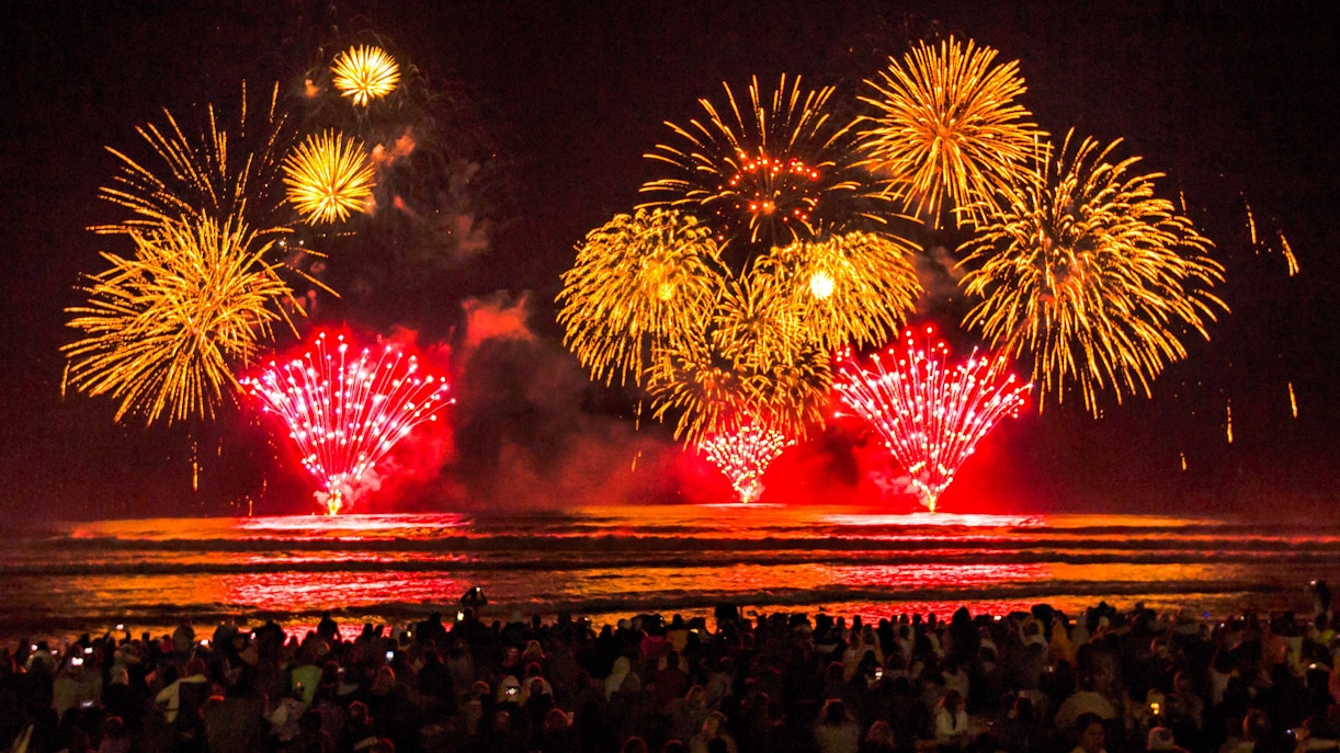 Fireworks display over Surfers Paradise Beach, Gold Coast, with a crowd watching.