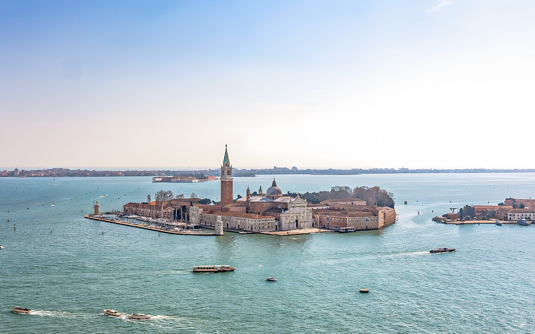Aerial view of San Giorgio Maggiore Island in Venice, Italy, with boats in the lagoon.