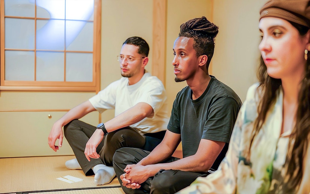 Tourists participating in a private tea ceremony with seasonal wagashi in a traditional Japanese room.