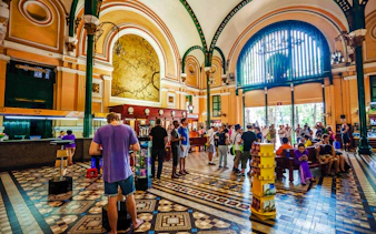 Ho Chi Minh City Central Post Office interior with visitors exploring and mailing postcards.