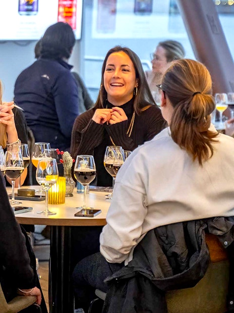 Group enjoying dinner on an Oslo cruise with wine glasses on the table.