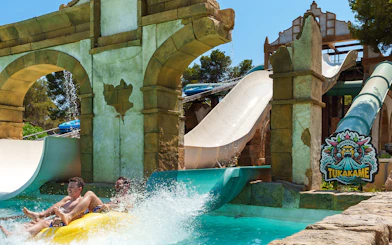 Tukakame water slide ride at Aqualand El Arenal with two people splashing into the pool.