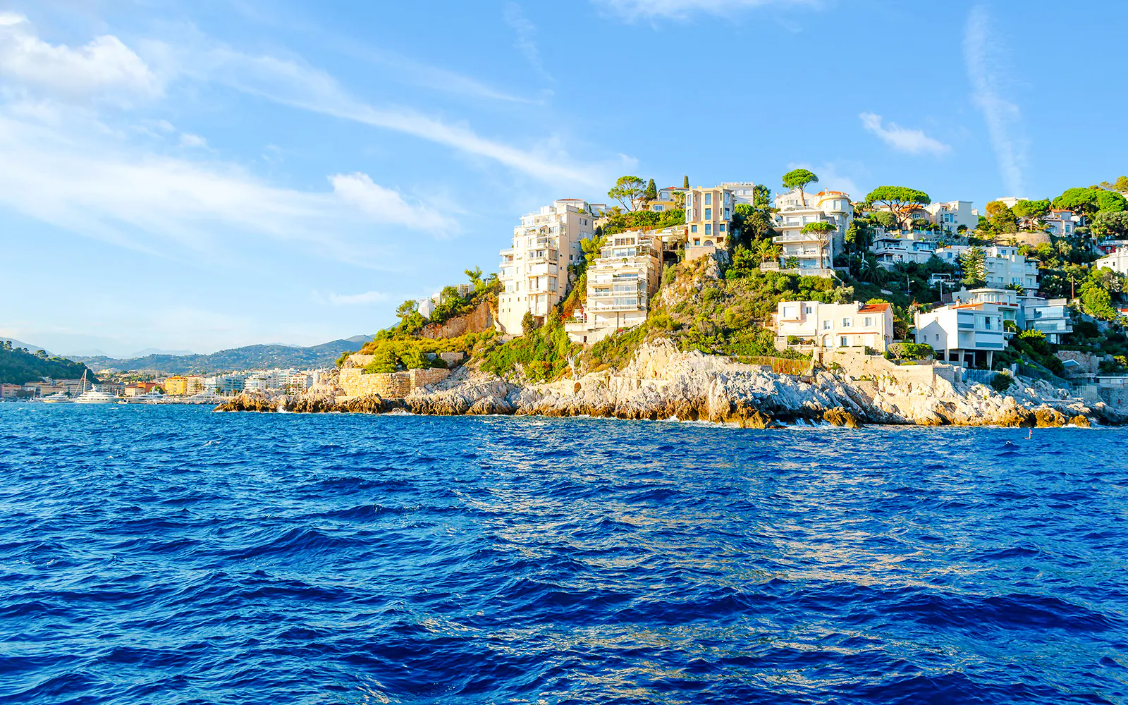 Coastal view of Cap de Nice with cliffside villas and the Mediterranean Sea.