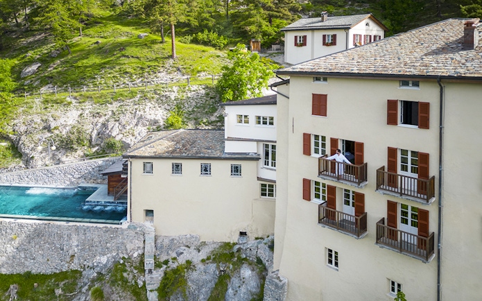 QC Terme Bagni Vecchi di Bormio spa with outdoor pool and scenic mountain view.