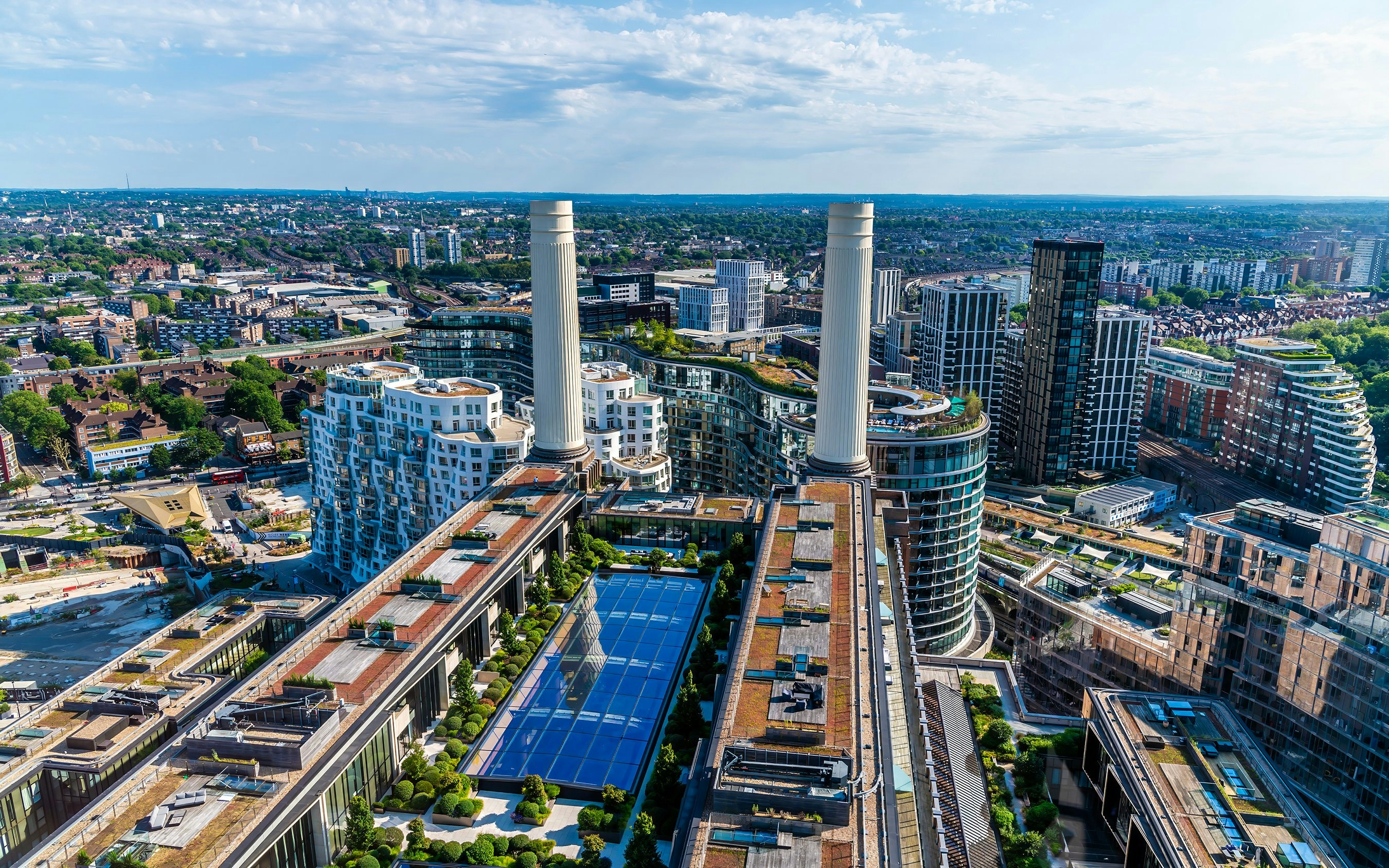 Aerial view south along Battersea Power Station roof, London, with surrounding cityscape.