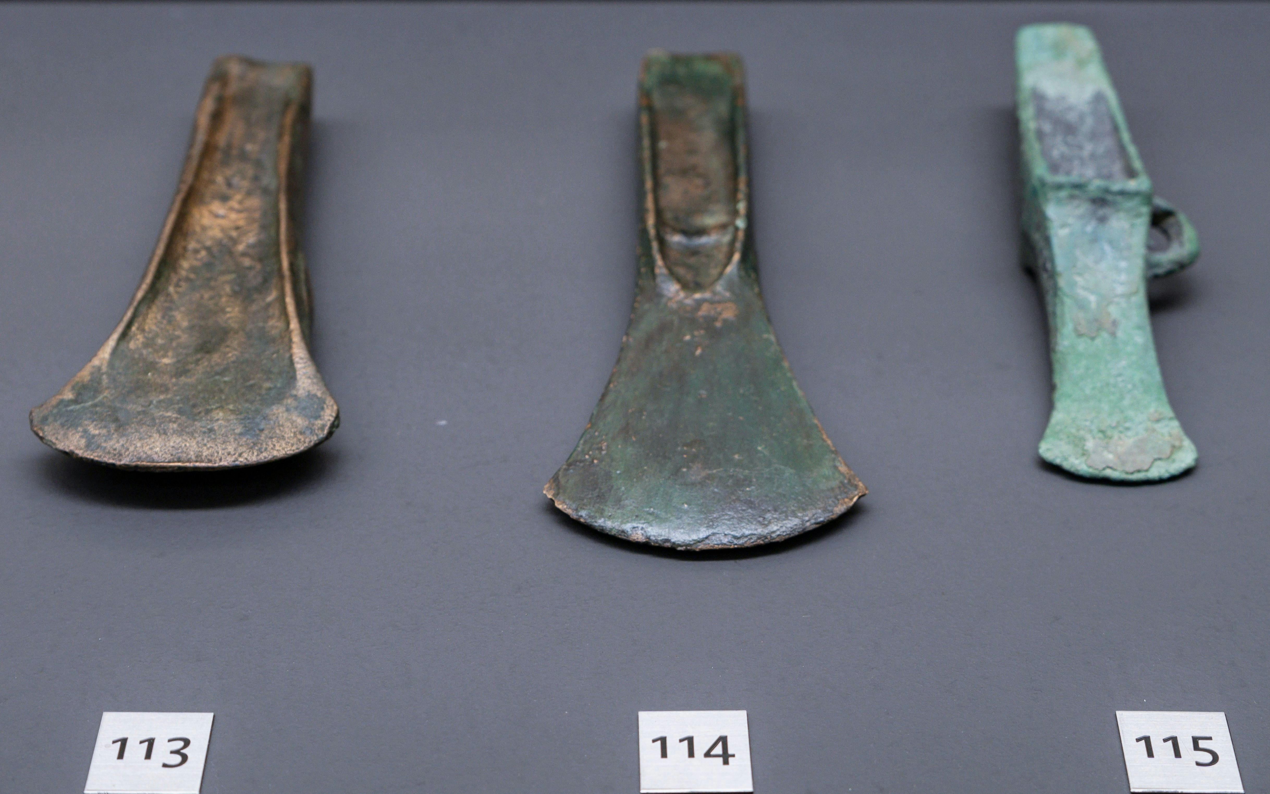 Bronze Age axes from 1800-900 BC displayed in a museum exhibit.