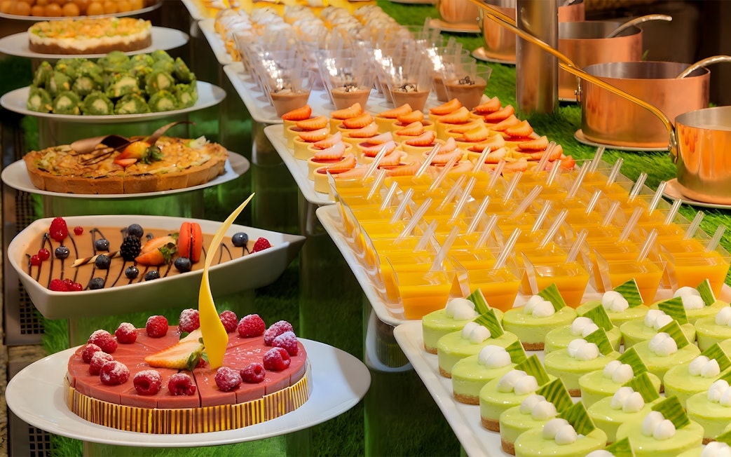 Dessert selection at Kaleidoscope buffet, Atlantis Dubai, featuring cakes and fruit tarts.
