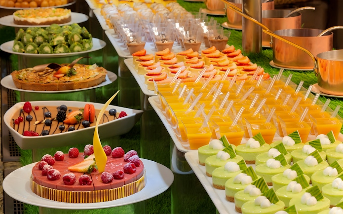 Dessert selection at Kaleidoscope buffet, Atlantis Dubai, featuring cakes and fruit tarts.