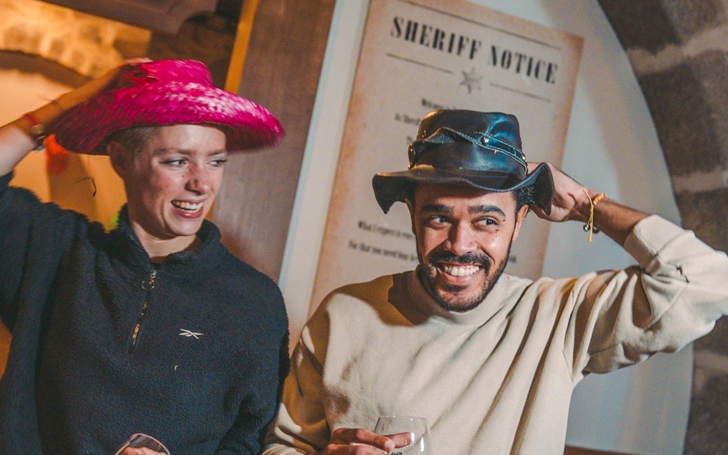 Guests enjoying a themed event at the Pink Palace with cowboy hats.