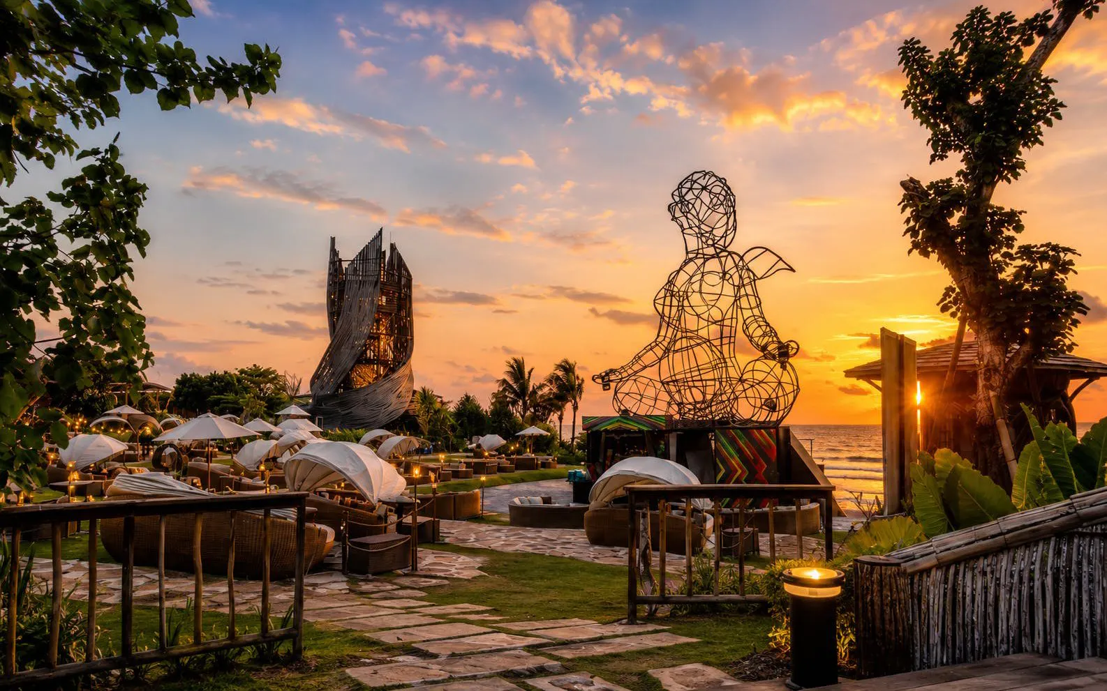 Luna Beach Club at sunset with wire sculpture and ocean view.