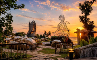 Luna Beach Club at sunset with wire sculpture and ocean view.