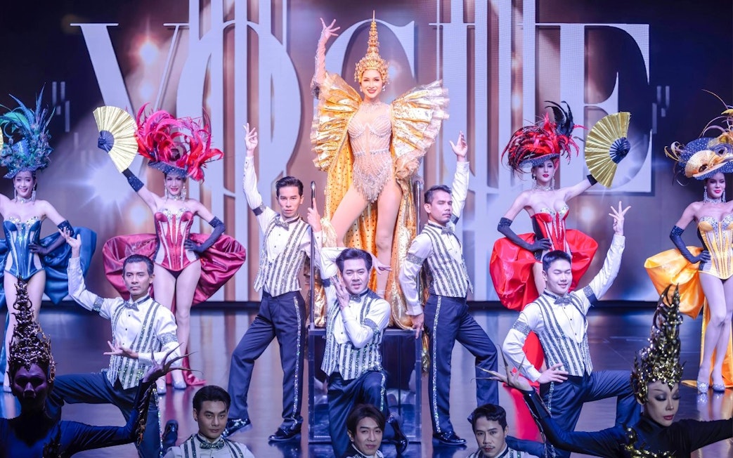 Calypso Cabaret performers in vibrant costumes on stage in Bangkok.