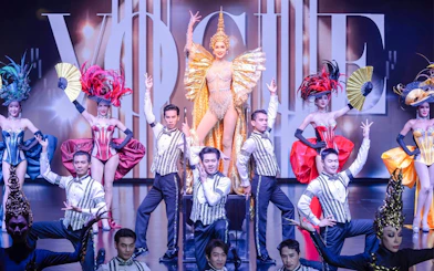 Calypso Cabaret performers in vibrant costumes on stage in Bangkok.